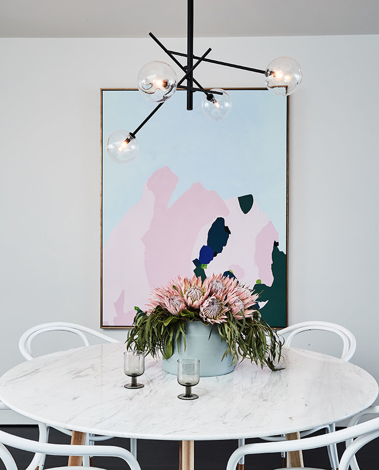 Marble dining table with bentwood dining chairs and abstract art via Rebecca Judd Loves