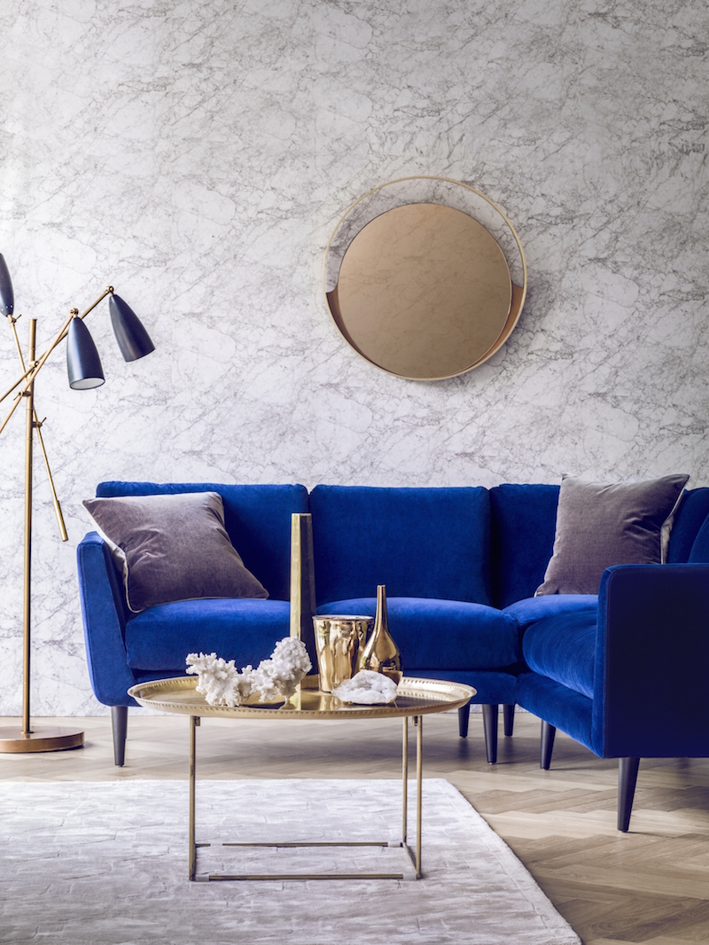 Blue Velvet Sofa (Holly Corner Sofa) with a gold coffee table and marble walls