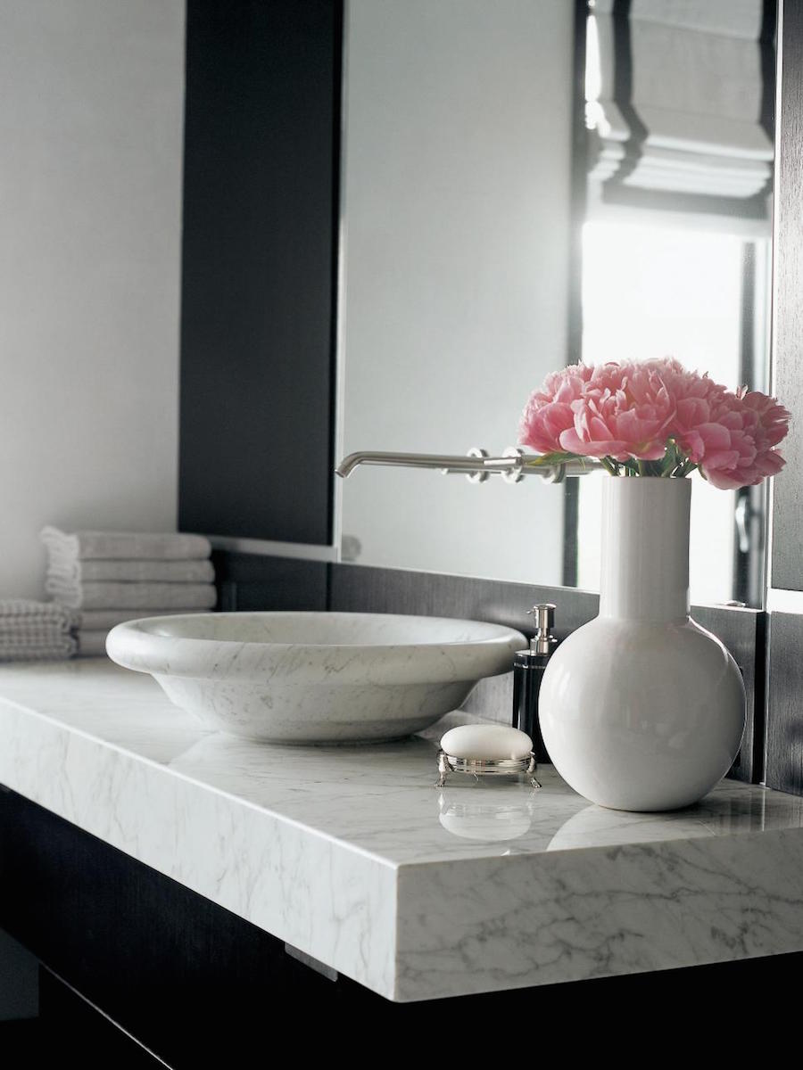 Black Cabinets and Raised Marble Sink with Pink Flowers