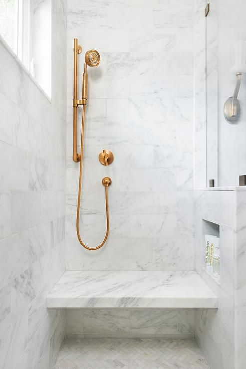 Brass Fixtures in a Marble Shower with Seat