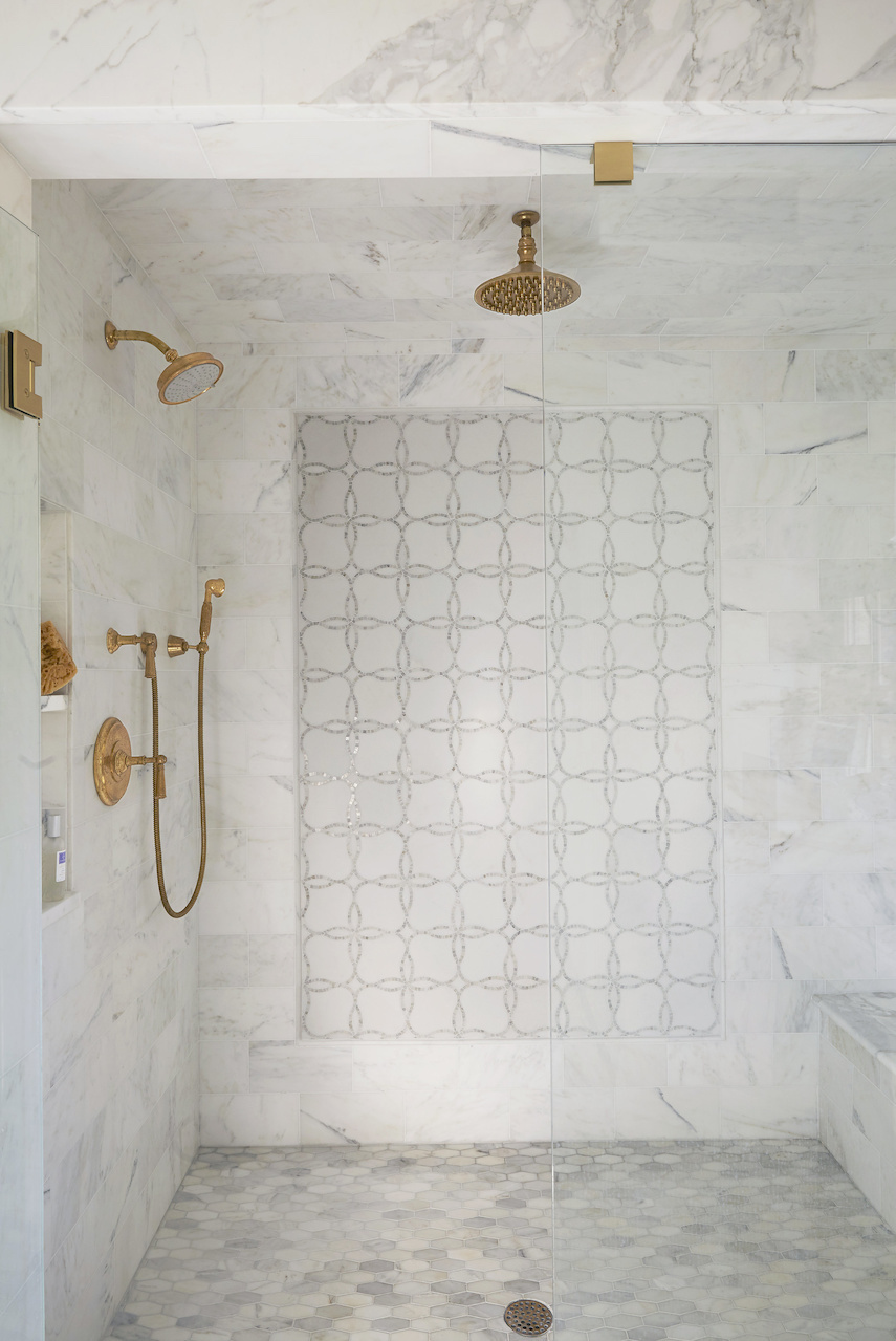 Brass Fixtures in a Walk-in Marble Shower