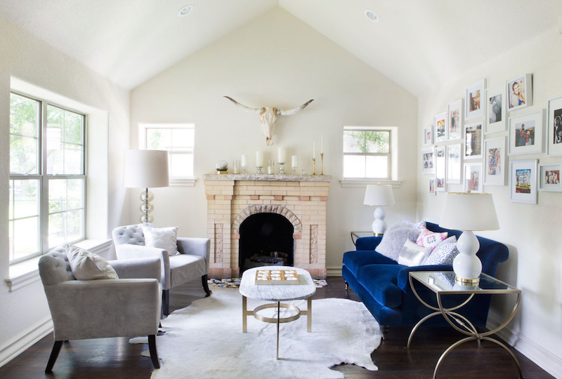 Claire Zinnecker Blue velvet sofa with fireplace and marble coffee table