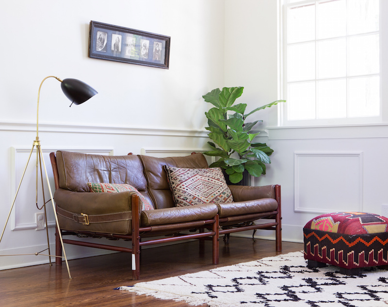 Claire Zinnecker Brown Leather couch with rug and poof