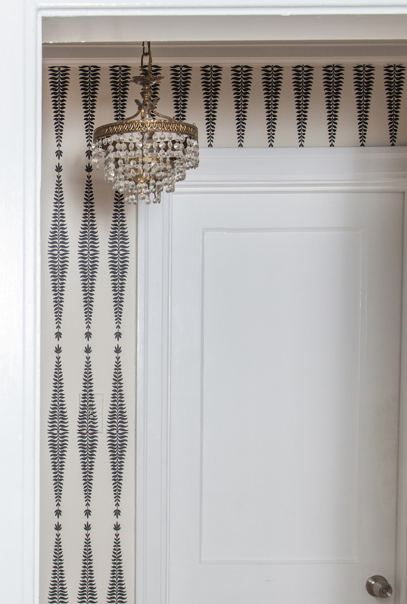 Claire Zinnecker Vintage chandelier with black and white wallpaper