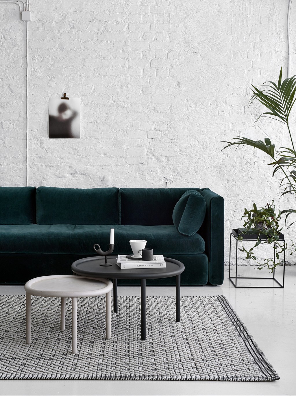 Scandi living room Dark Green Velvet Sofa against White Brick Wall