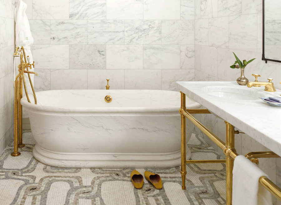 Greenwich Hotel Brass Fixtures in a Marble bathroom with freestanding tub