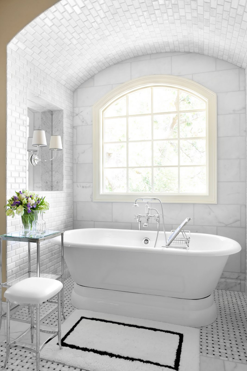 Marble Tile Wall Tub with Silver Fixtures on a Freestanding Tub with an Arched Window