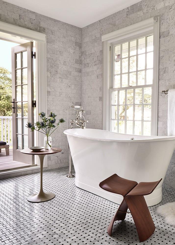 White Tub in Marble Bathroom with Brown Chair
