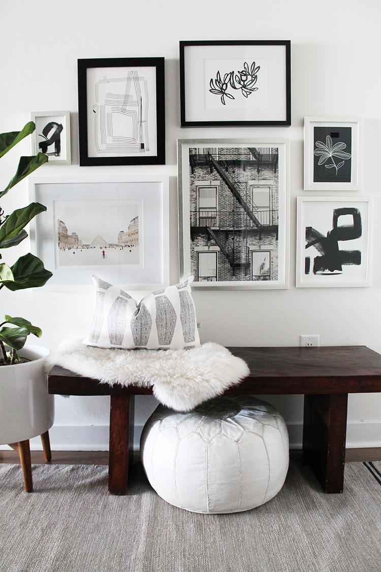 Black and white Gallery wall entryway with dark wood bench