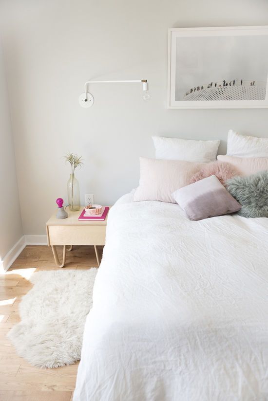 Blush throw pillows on a white bed