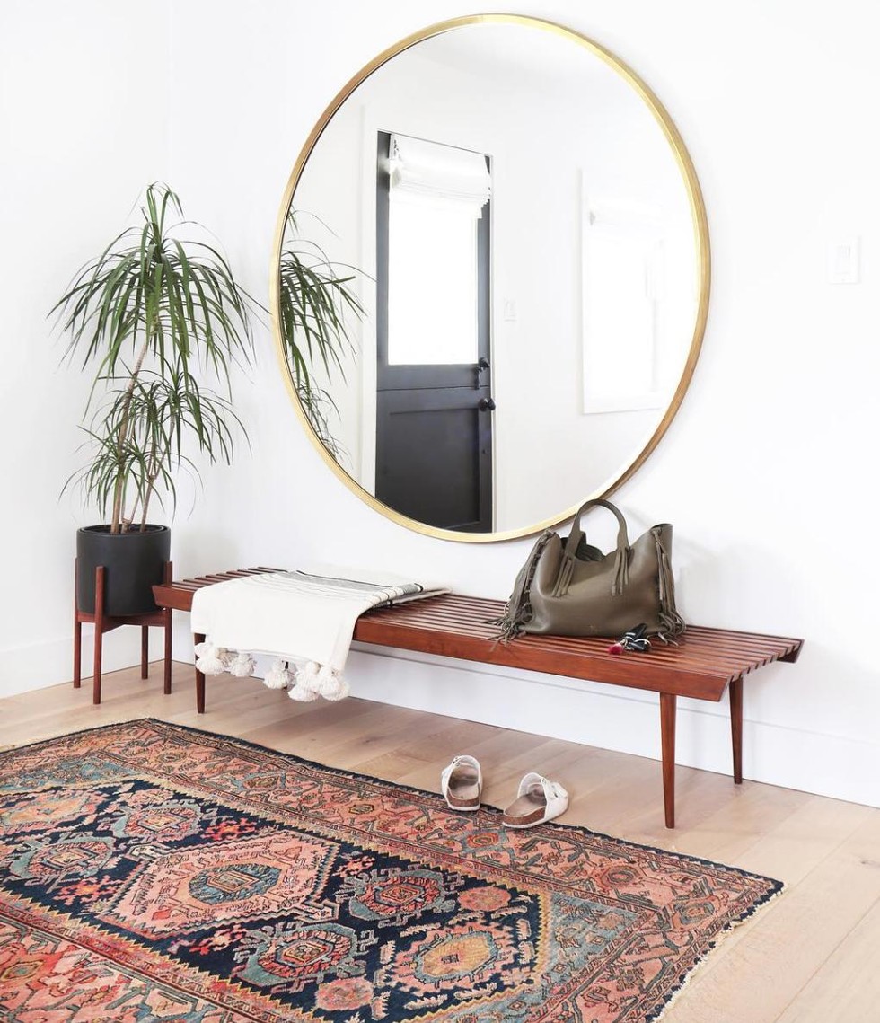 Vintage Rug interior with wood bench and oversized mirror via Amber Interiors