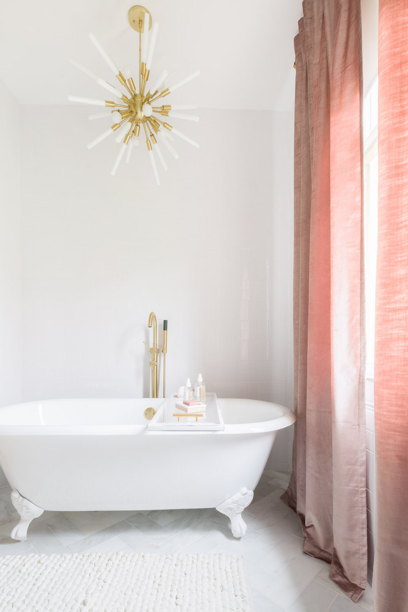 White bathtub with pink curtains by Alyssa Rosenheck