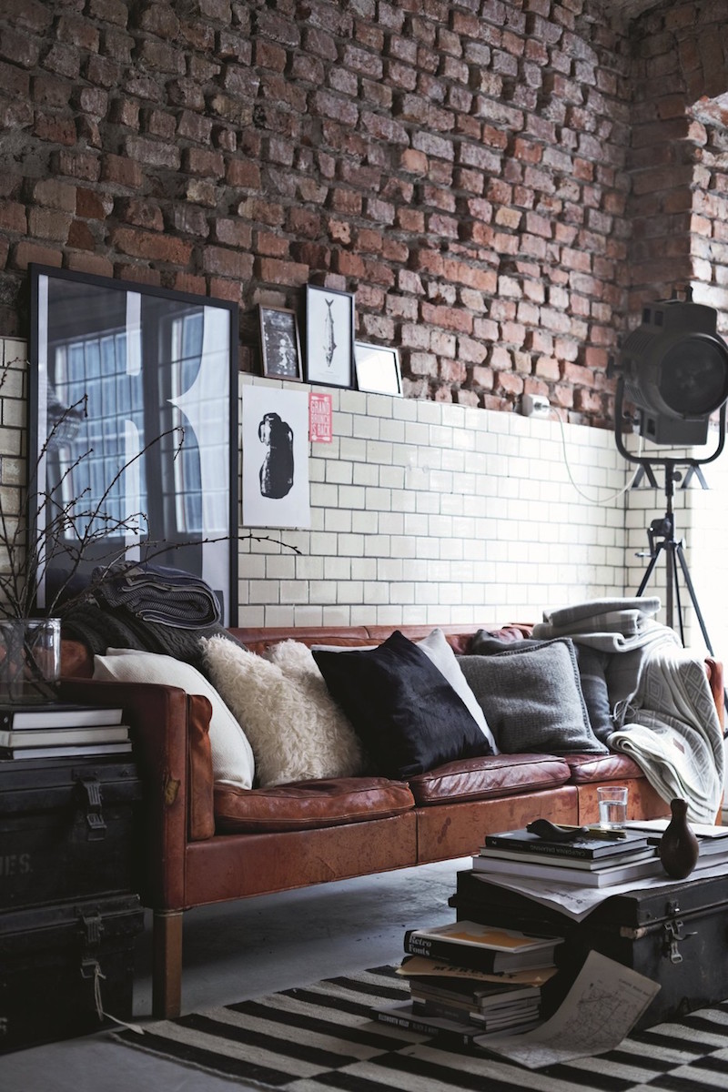 Brown leather sofa against brick wall via Gant