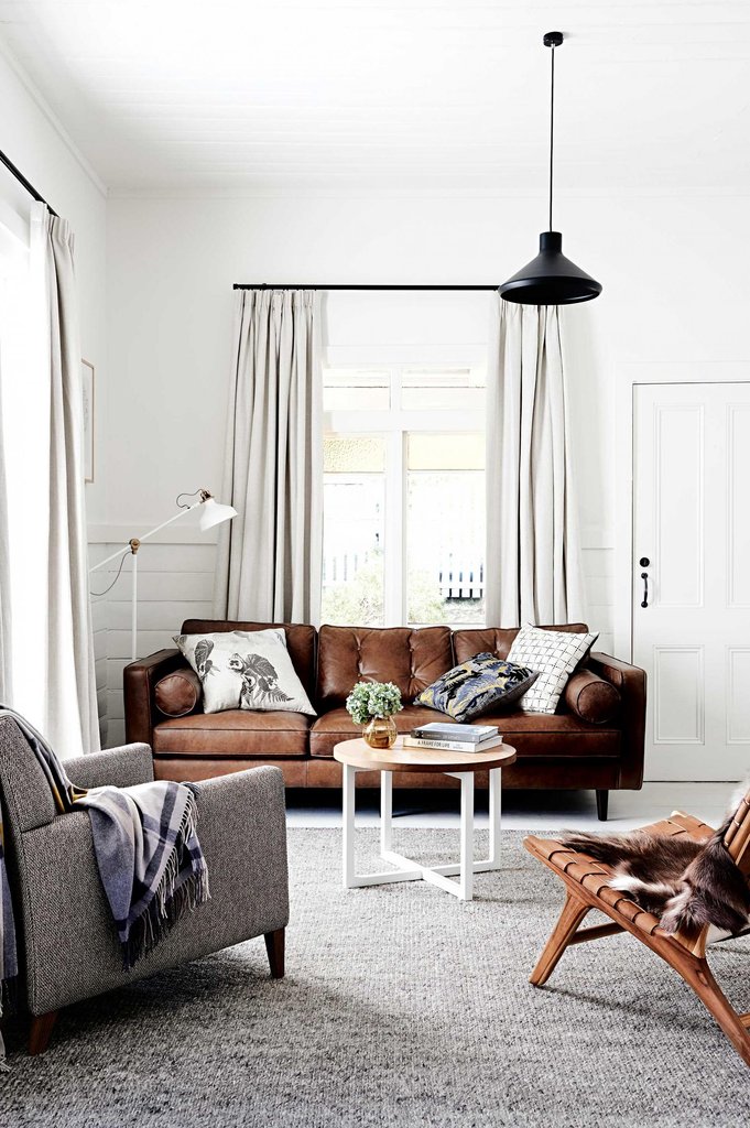 brown leather couch with gray chairs