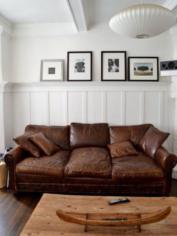 Distressed brown leather couch against white wall