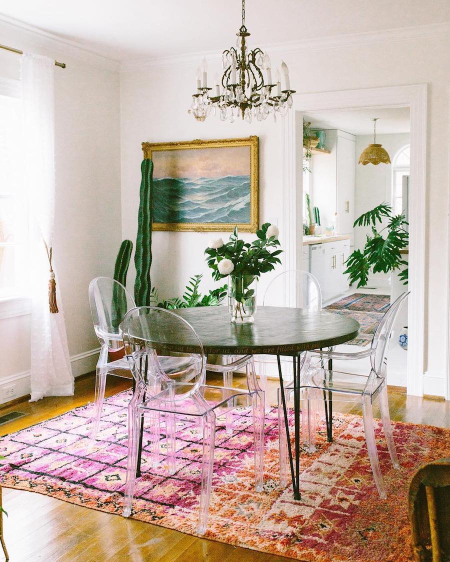 Ghost chairs with dark table and multicolor rug