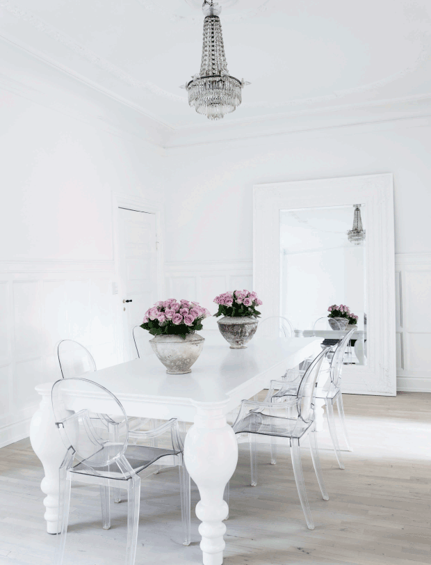 Ghost chairs with white dining table and crystal chandelier