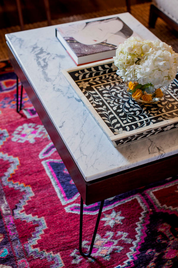 Marble coffee table with red rug via Design Manifest