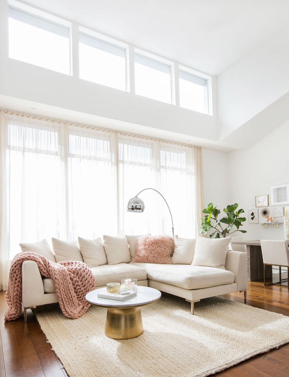 Neutral couch with blush pink throw and pillows with marble table