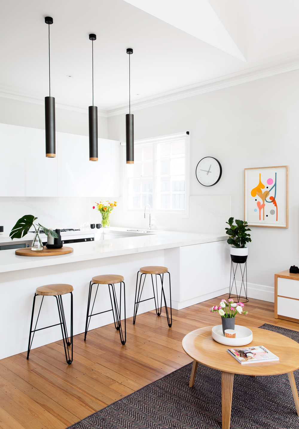 Hardwood Flooring in a white kitchen with brown stools