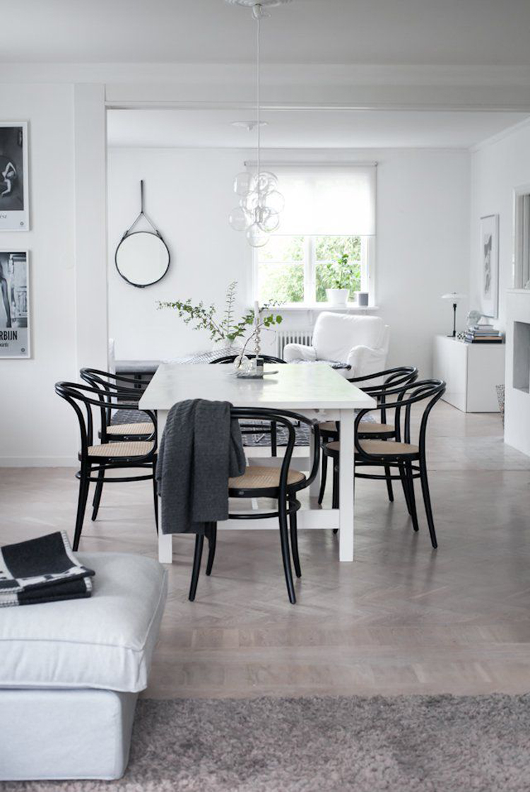 Black bentwood chairs around white dining table via House of Philia