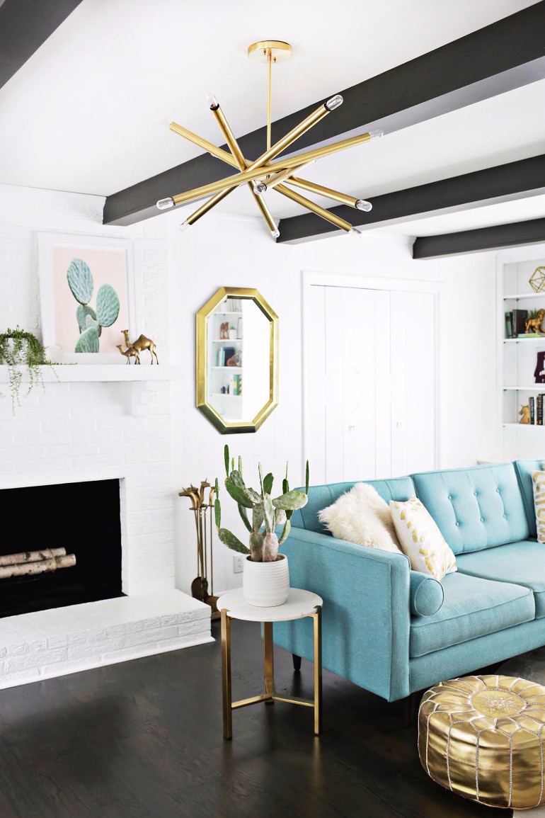 Starburst chandelier in living room with blue sofa via A Beautiful Mess