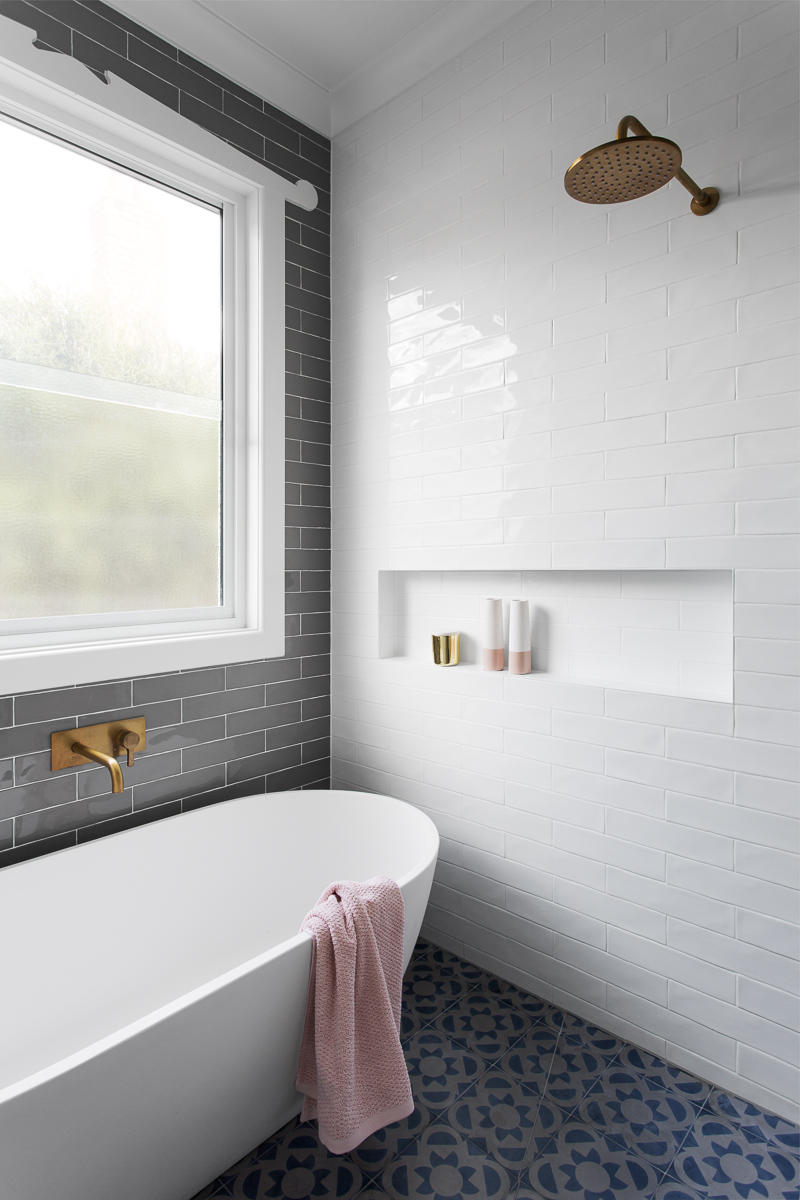 White bathtub with brass shower