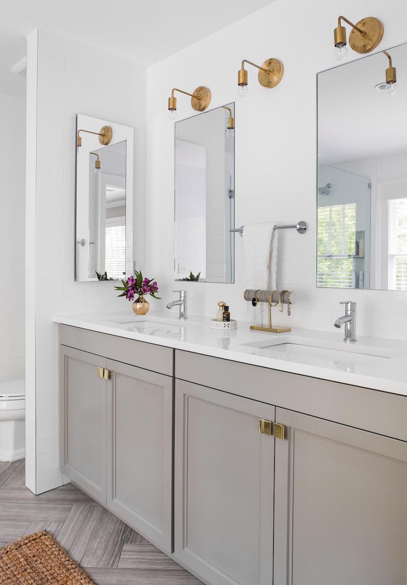 Brass sconces above bathroom vanity