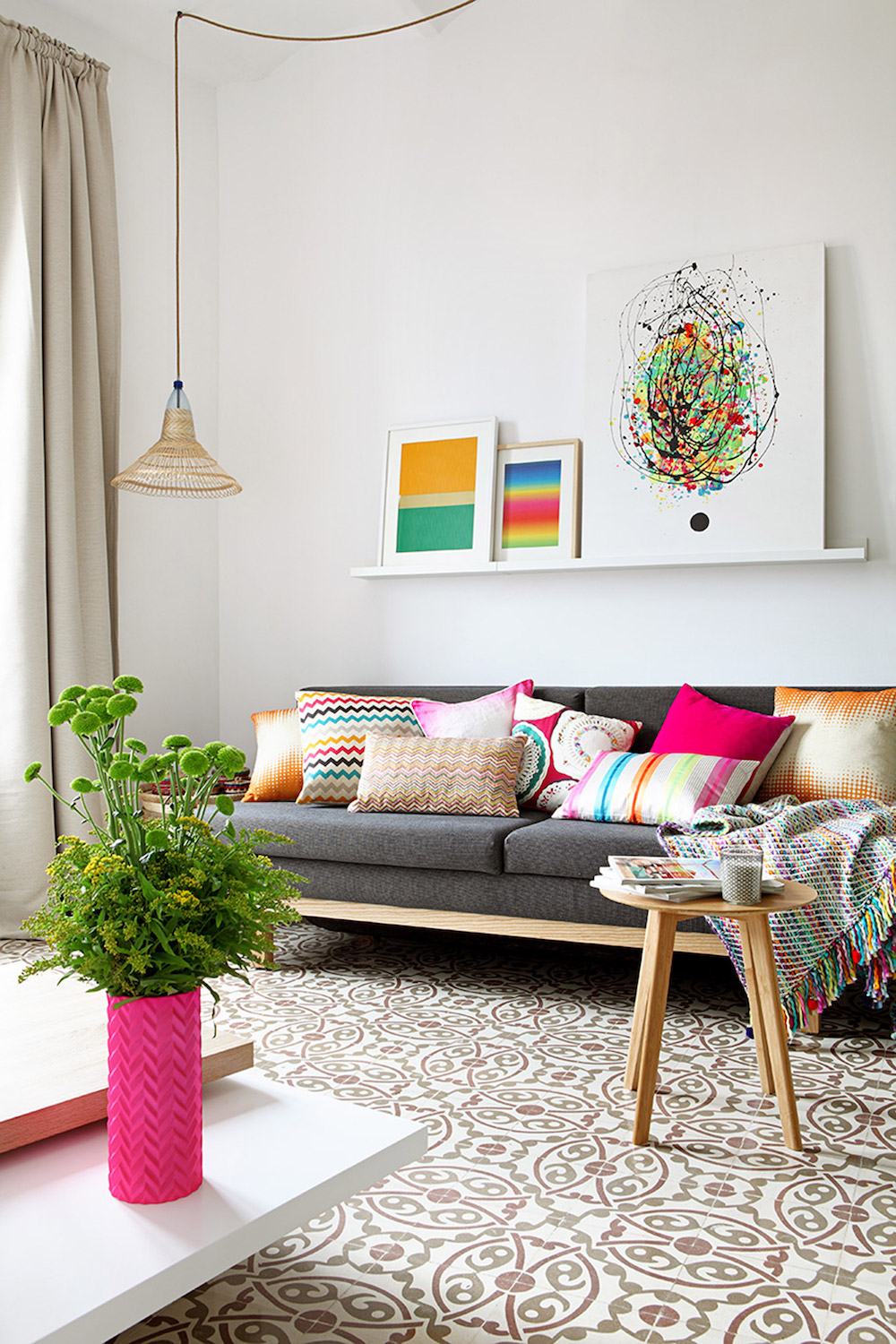 Grey couch in Barcelona apartment with multi-color throw pillows