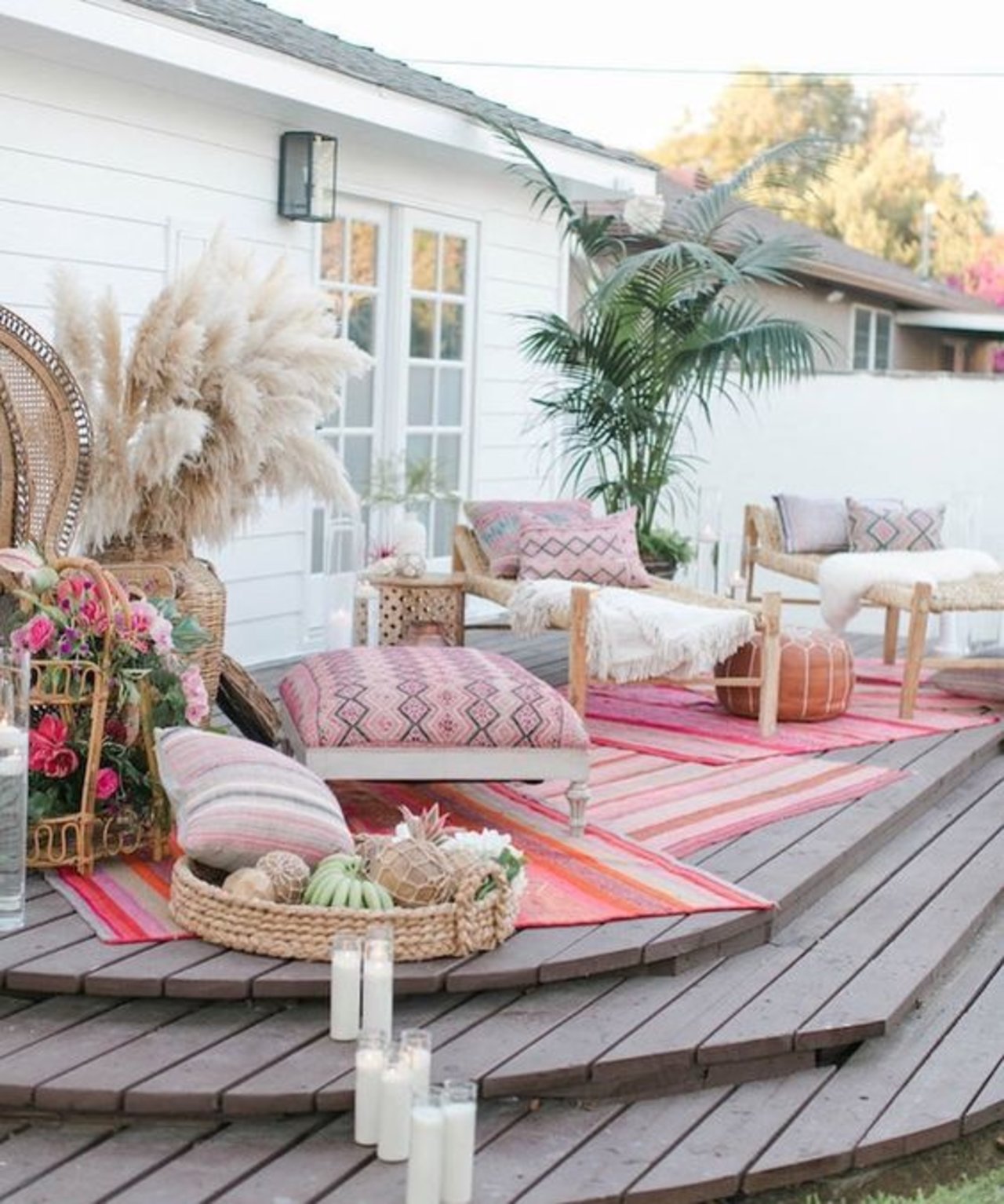 Outdoor deck with pink rugs and pillows