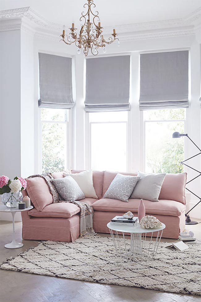 Soft pink sectional sofa with gold chandelier