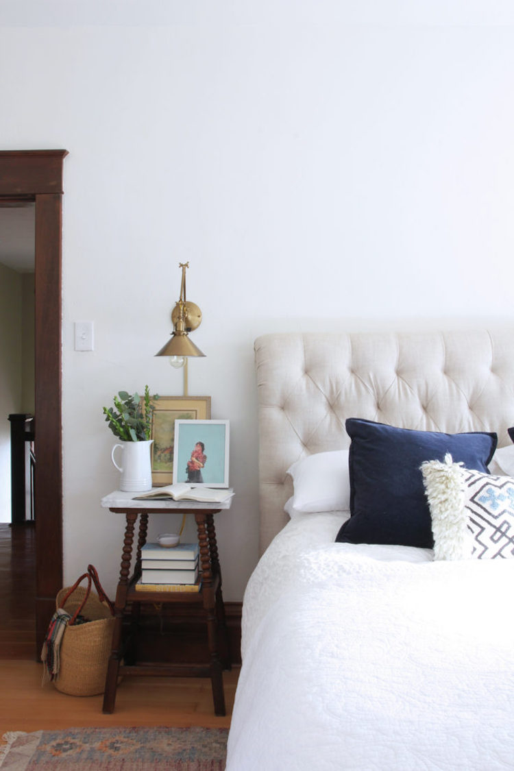 Brass Sconce next to bed in farmhouse home via The Grit and Polish