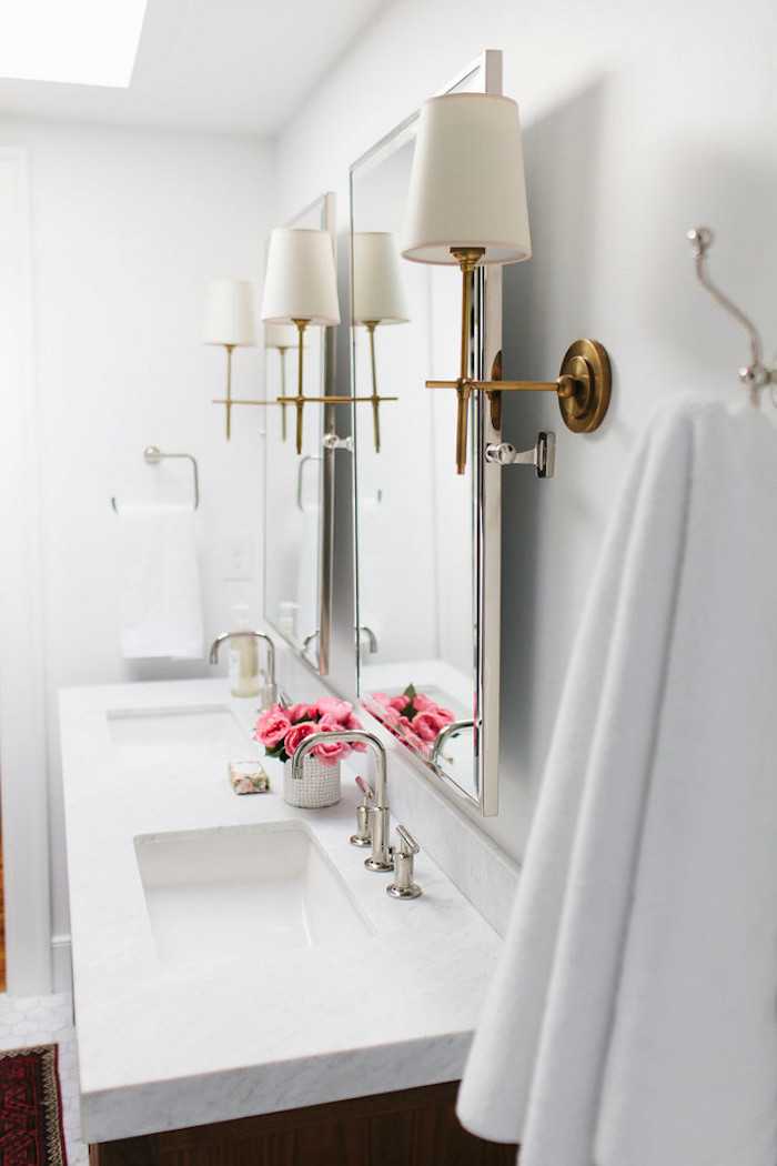 Brass sconces with double vanity in bathroom by Shea McGee Design