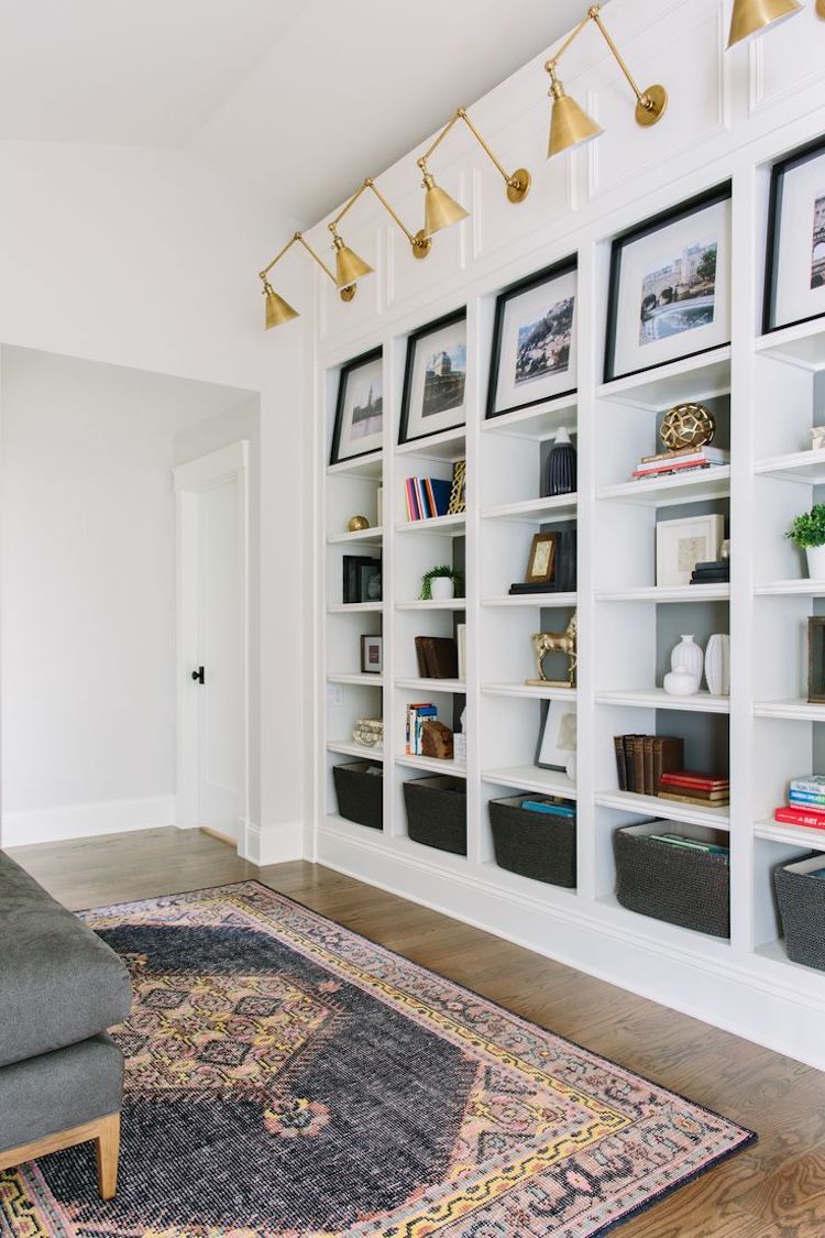 Gold arm sconces above bookshelves via Kate Marker Interiors