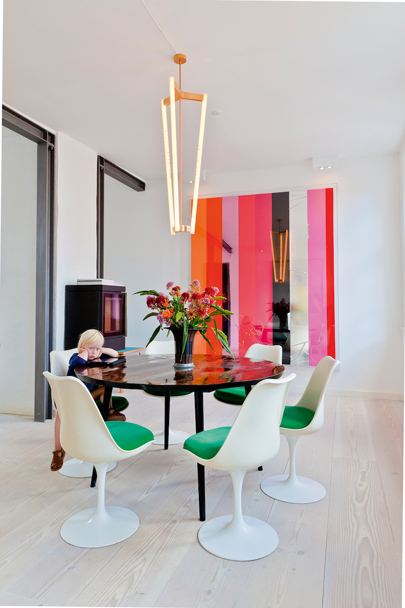 Green cushion white dining chairs with pink striped artwork