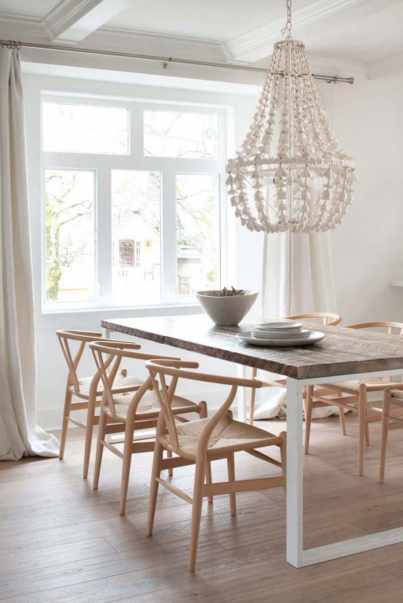 Neutral dining room with wishbone chairs and beaded chandelier via Mount Royal Developments