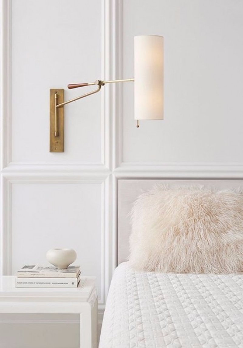 White bedroom with brass wall sconce via Circa Lighting