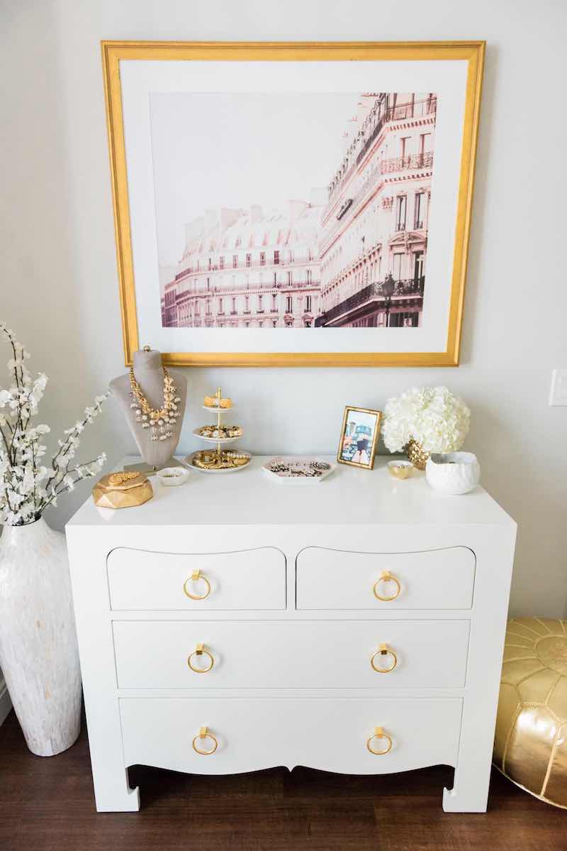 White dresser with gold ring pulls and Paris art