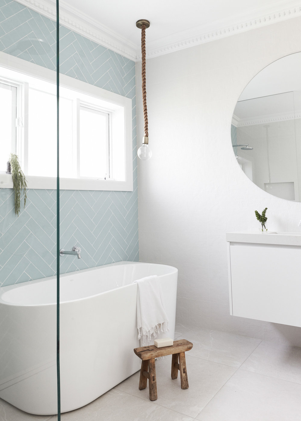 Bathroom with white freestanding tub and rope lightbulb