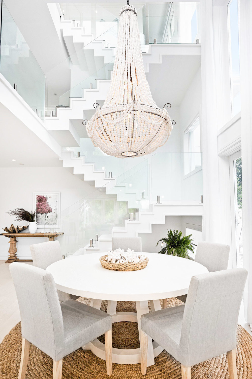 Dining room with grey chairs and white beaded chandelier