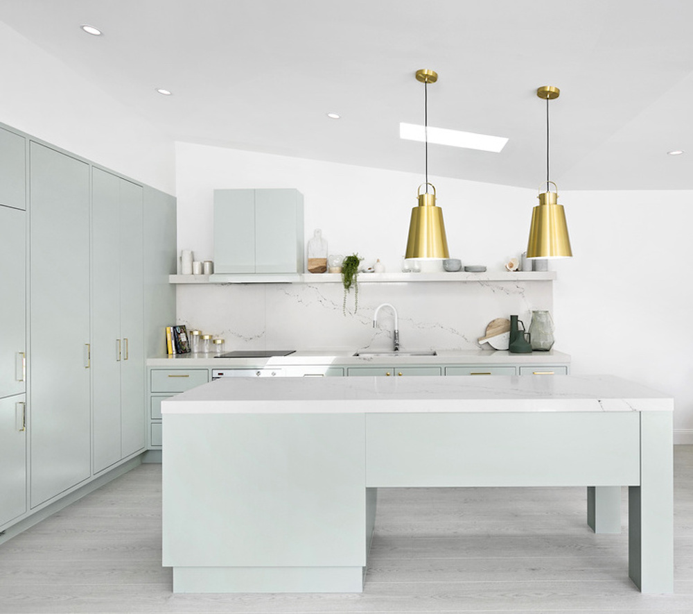 Kitchen with mint green cabinets and gold pendant lighting