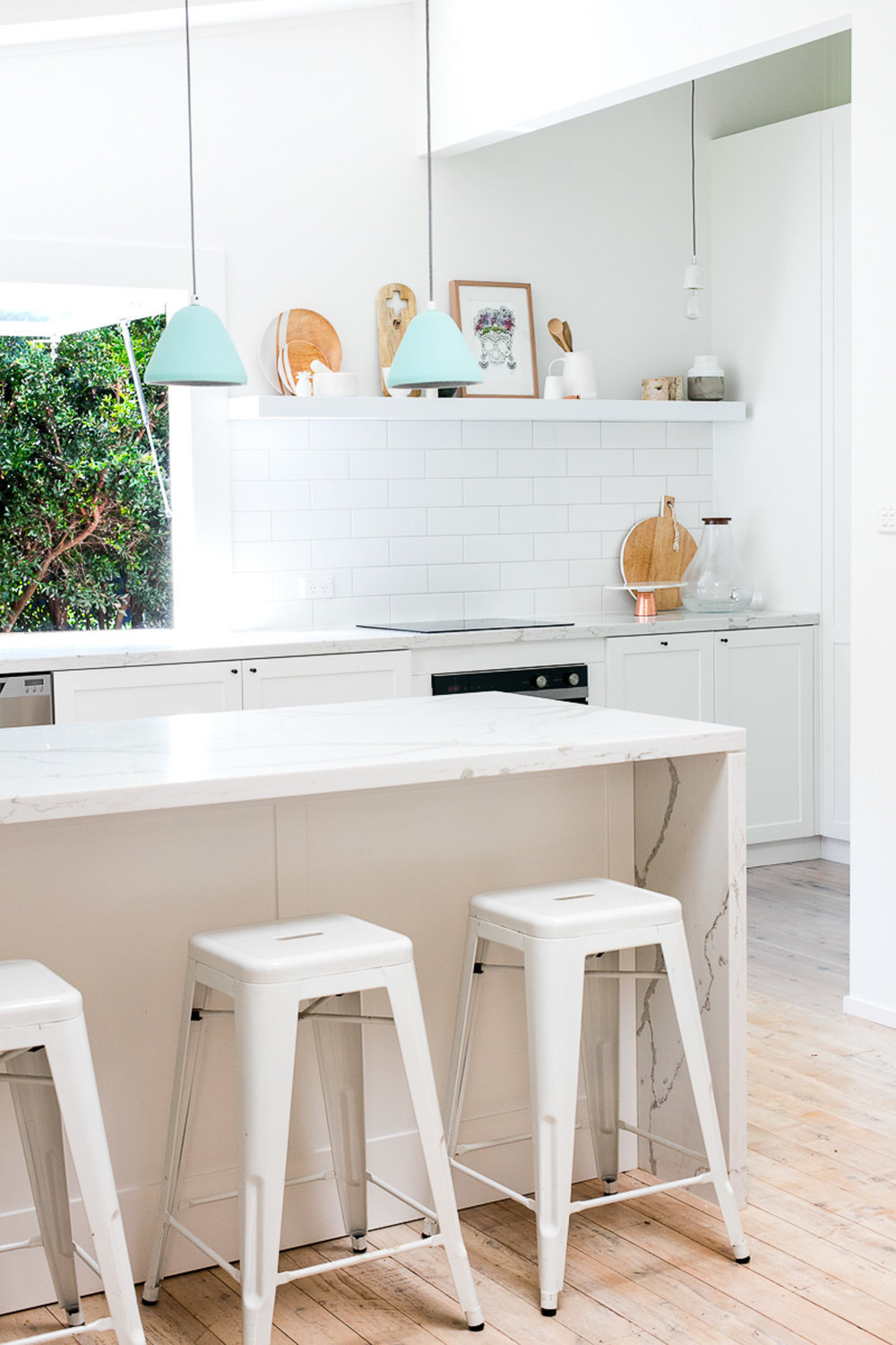 Kitchen with white marble and soft blue pendant lights