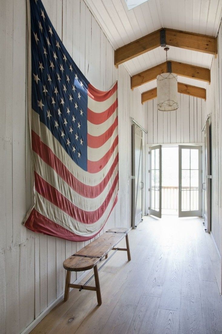 Large old American flag hangs in the hallway of a white painted barn