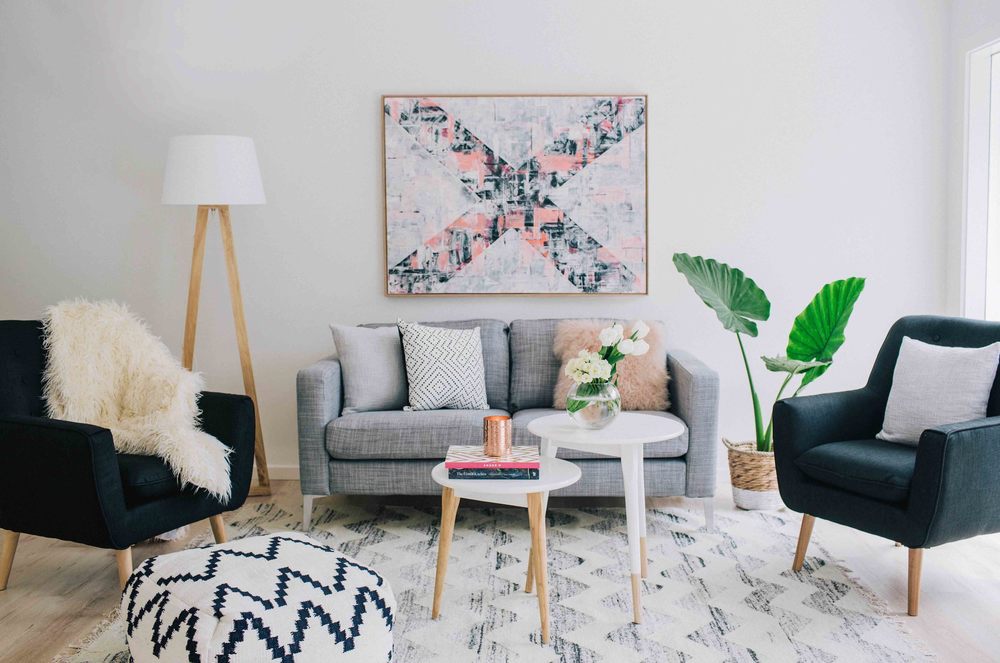 Living room with gray couch and 2 side tables as coffee tables. Design by Three Birds Renovations