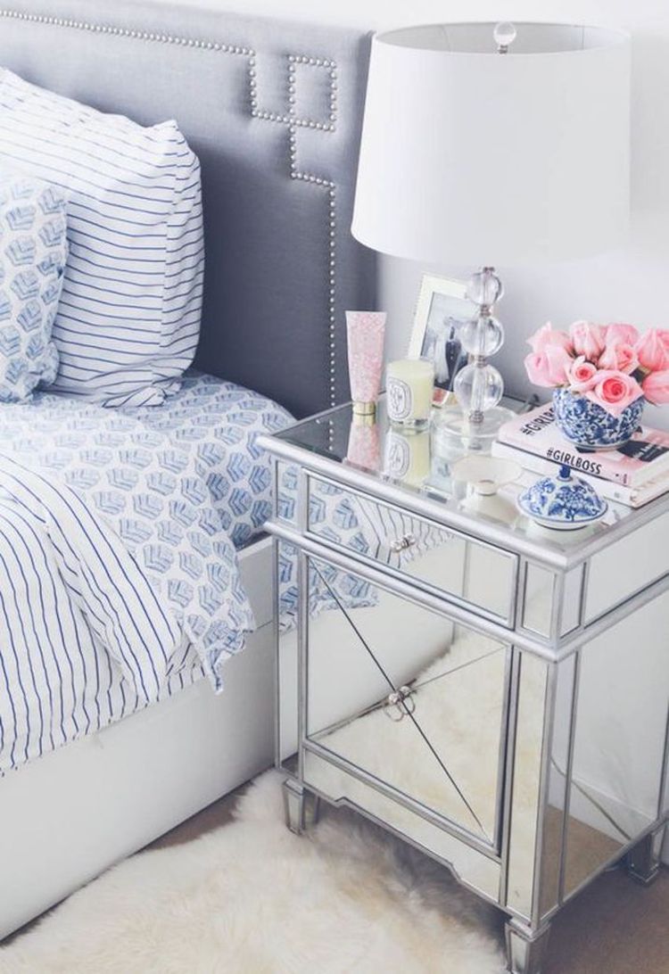 Mirrored nightstand with table lamp, girlboss book, and candle