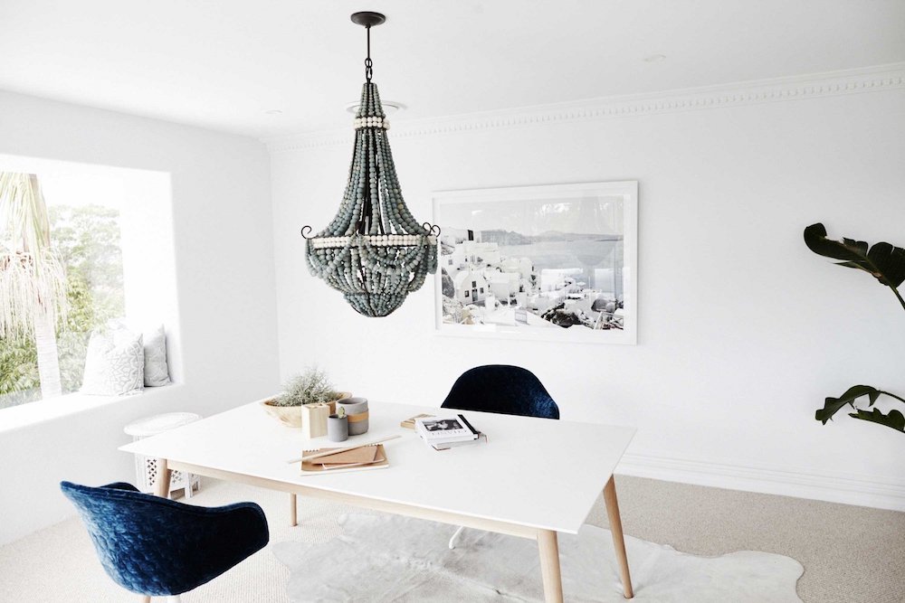 Office with beaded chandelier and blue velvet chairs