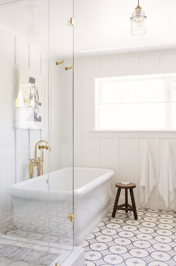 Grey and black floor tile in bathroom with white rectangular tub via HSH Interiors