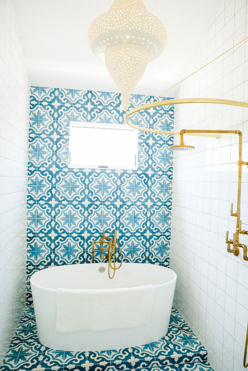 Turquoise Spanish tiling behind white oval tub