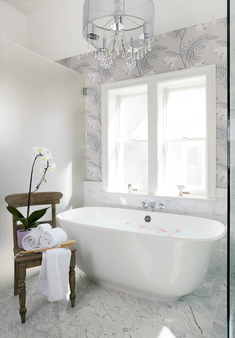 White bathtub with lavender floral wallpaper