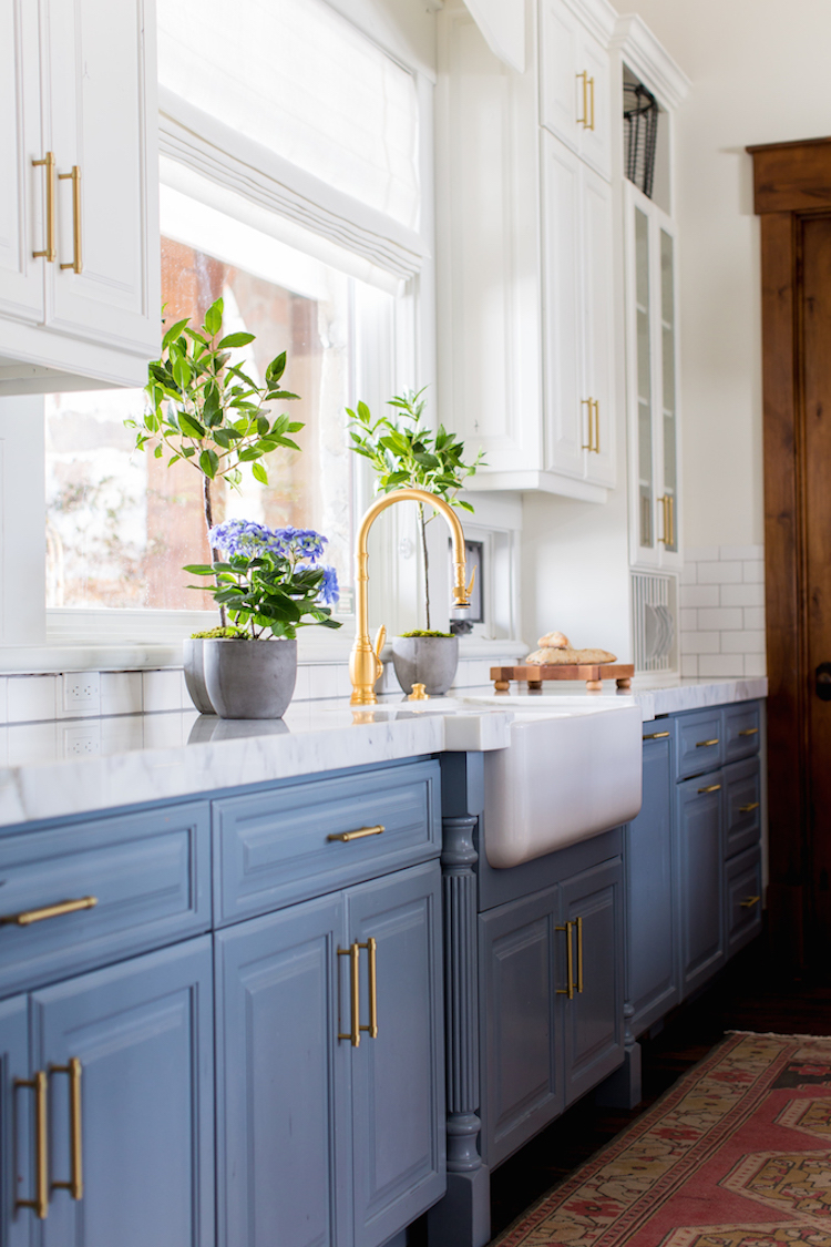 6 Mooie Farmhouse Spoelbakken Schort Front Spoelbakken Voor De Keuken   White Farmhouse Sink With Blue Kitchen Cabinets Via Becki Owens 